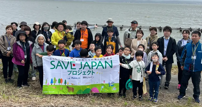 SAVE JAPANプロジェクトの参加者が、活動の横断幕を掲げて集合する様子
