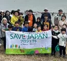 SAVE JAPANプロジェクトの参加者が、活動の横断幕を掲げて集合する様子